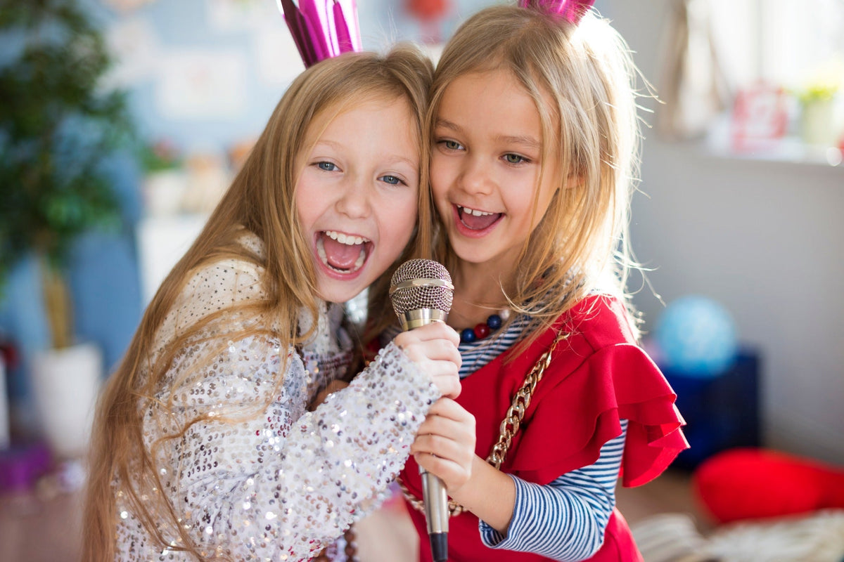 Kids singing together with microphones at a karaoke night slumber party